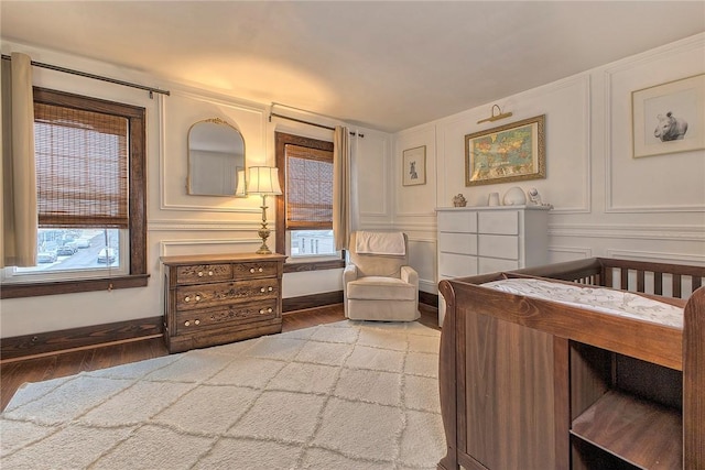 bedroom with a crib and hardwood / wood-style flooring