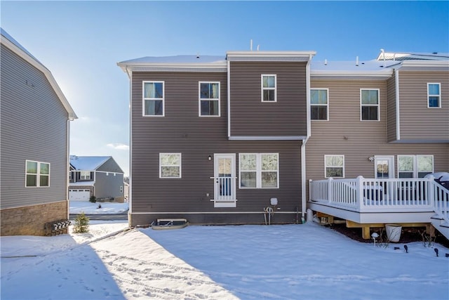 snow covered rear of property featuring a deck