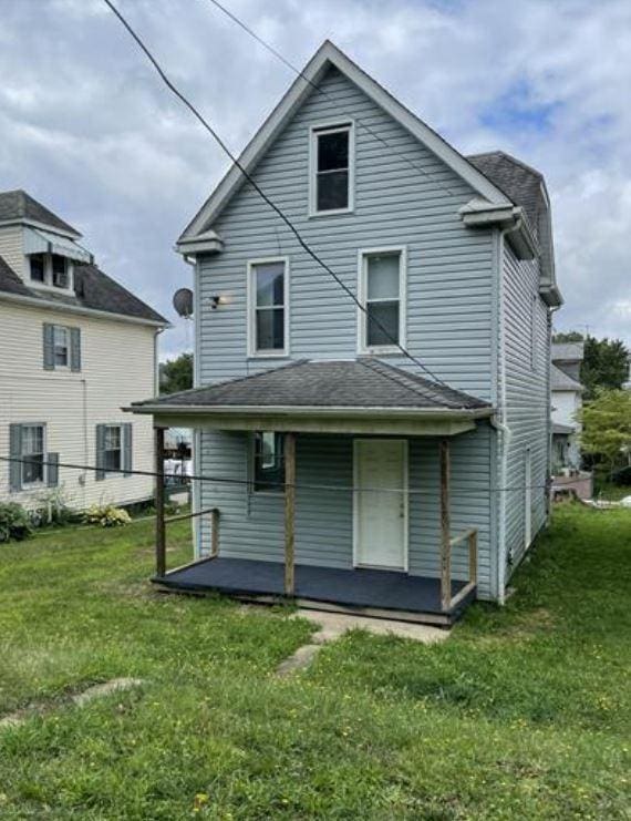 rear view of property with a yard and covered porch