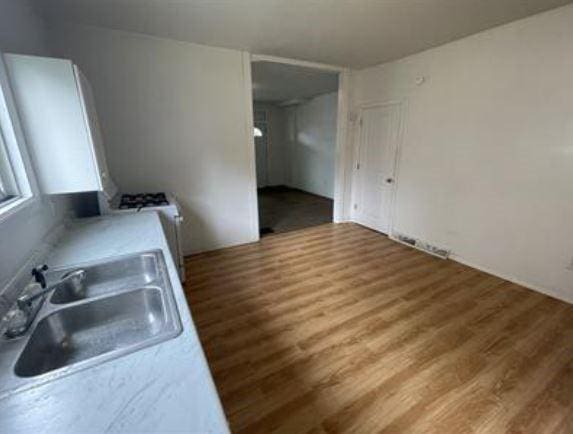 kitchen featuring sink, white cabinets, and hardwood / wood-style flooring