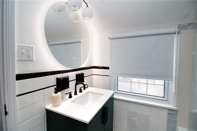 bathroom featuring vanity and tile walls