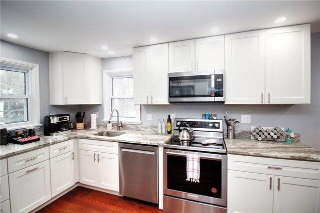 kitchen featuring sink, appliances with stainless steel finishes, a healthy amount of sunlight, and white cabinetry