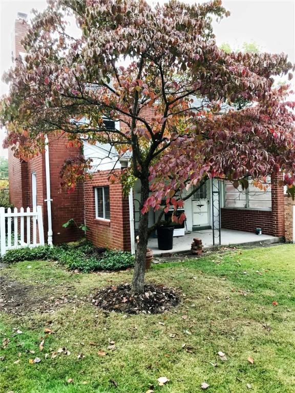 view of side of home with a lawn and a patio