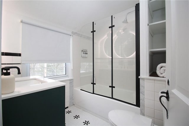 full bathroom featuring enclosed tub / shower combo, tile patterned floors, vanity, and toilet