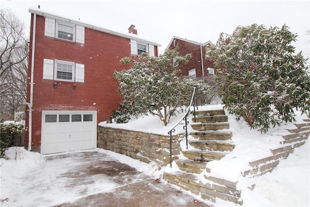 view of snowy exterior featuring a garage