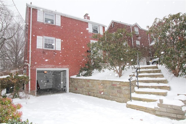 snow covered building featuring a garage