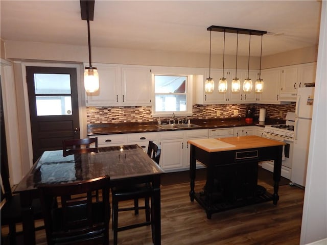 kitchen with sink, white cabinets, a center island, and white appliances