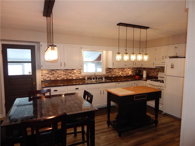 kitchen with white cabinets, sink, white appliances, and a center island