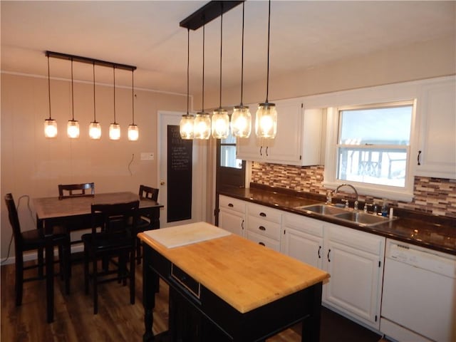 kitchen featuring backsplash, decorative light fixtures, white dishwasher, white cabinets, and sink