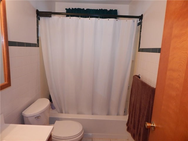 full bathroom with tile walls, toilet, vanity, and shower / bath combo