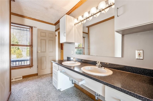 bathroom featuring a textured ceiling, ornamental molding, and vanity