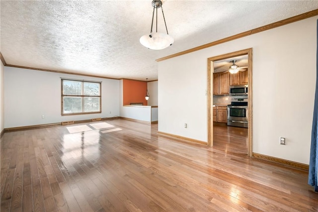 unfurnished living room with light wood-type flooring, ceiling fan, ornamental molding, and a textured ceiling