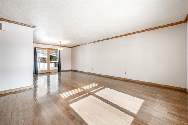 unfurnished room featuring hardwood / wood-style floors, ornamental molding, and a textured ceiling