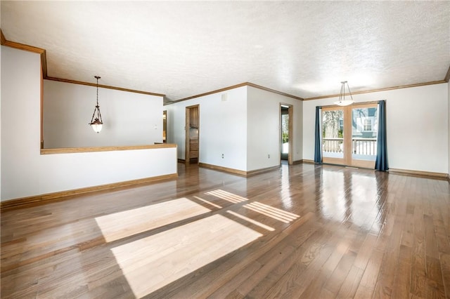 unfurnished living room with wood-type flooring, crown molding, and a textured ceiling