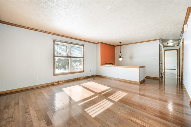 interior space with light wood-type flooring, a textured ceiling, and crown molding