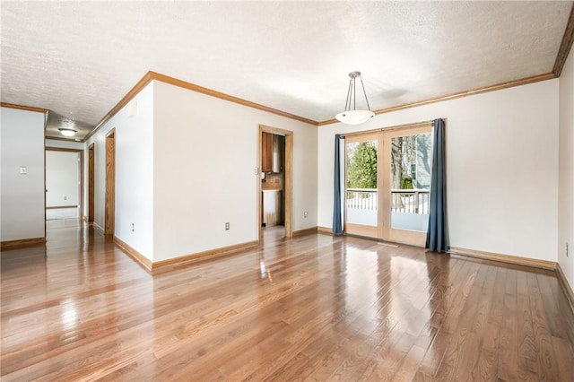 spare room featuring crown molding, a textured ceiling, and hardwood / wood-style flooring