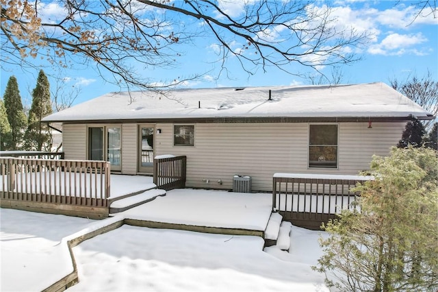 snow covered rear of property with central air condition unit