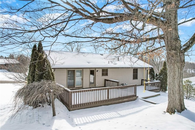 snow covered house with a deck