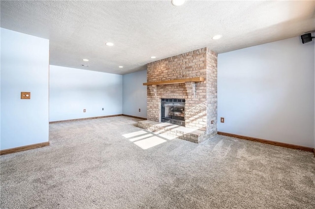 unfurnished living room featuring carpet, a brick fireplace, and a textured ceiling