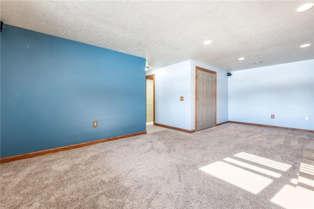 empty room featuring light colored carpet and a textured ceiling