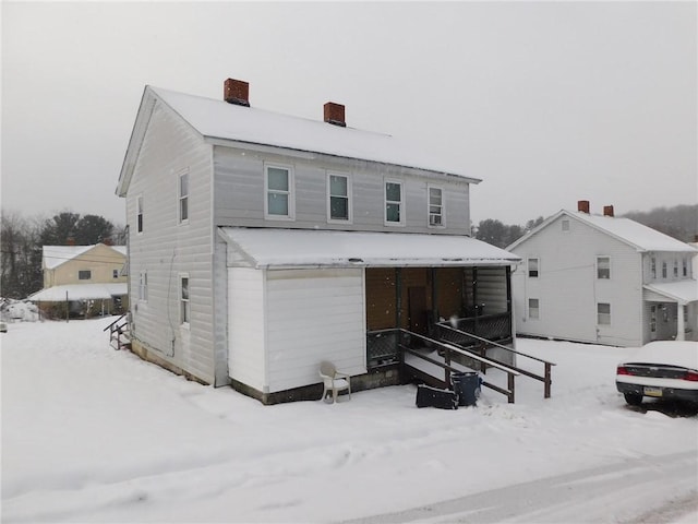 view of snow covered back of property