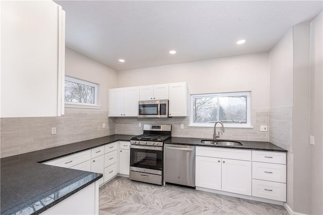 kitchen featuring sink, white cabinets, appliances with stainless steel finishes, and plenty of natural light