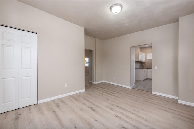 unfurnished bedroom featuring light wood-type flooring and a closet