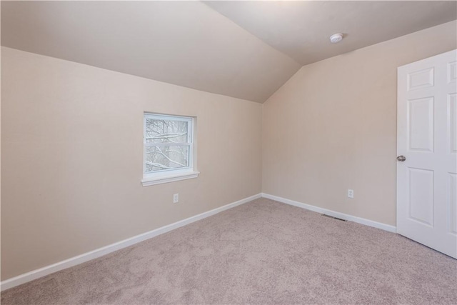 additional living space with light carpet and vaulted ceiling