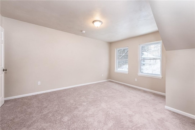 carpeted spare room with lofted ceiling