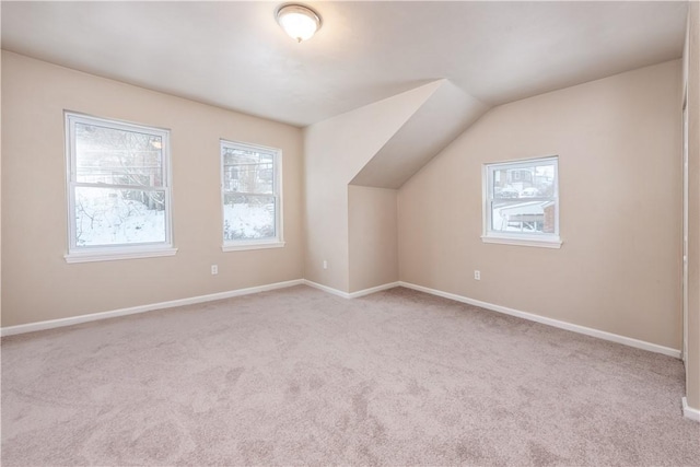 bonus room featuring light carpet and vaulted ceiling