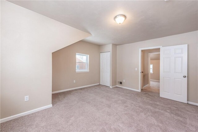 bonus room featuring lofted ceiling and light colored carpet