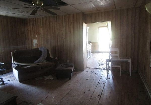 sitting room with ceiling fan, hardwood / wood-style flooring, and wooden walls