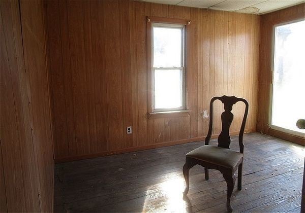 interior space with dark hardwood / wood-style floors, wood walls, and a healthy amount of sunlight