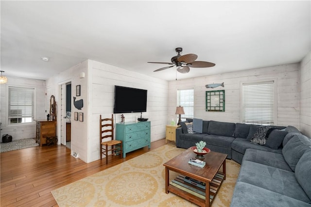 living room featuring wood walls, ceiling fan, and hardwood / wood-style floors