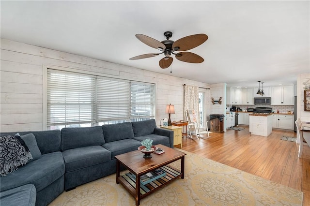 living room featuring ceiling fan and light hardwood / wood-style flooring