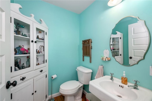 bathroom featuring toilet, wood-type flooring, and sink