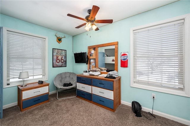 living area featuring ceiling fan, plenty of natural light, and carpet flooring