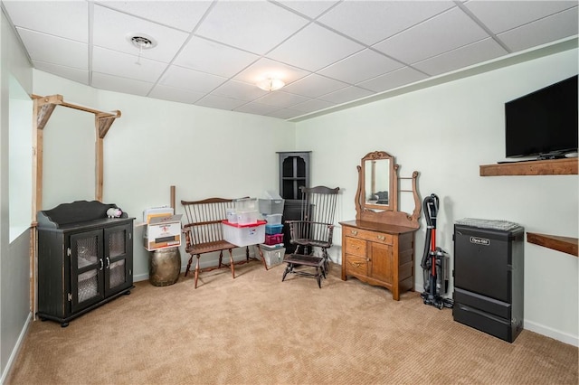 carpeted office with a paneled ceiling