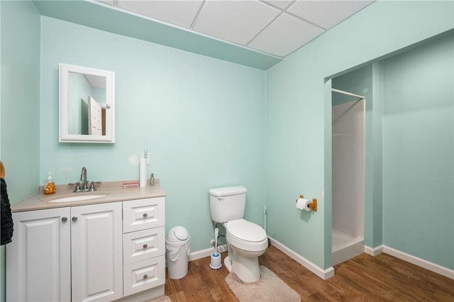 bathroom with vanity, a drop ceiling, a shower, and hardwood / wood-style floors