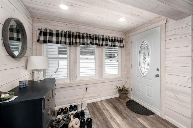 foyer with hardwood / wood-style flooring, wood ceiling, and wooden walls