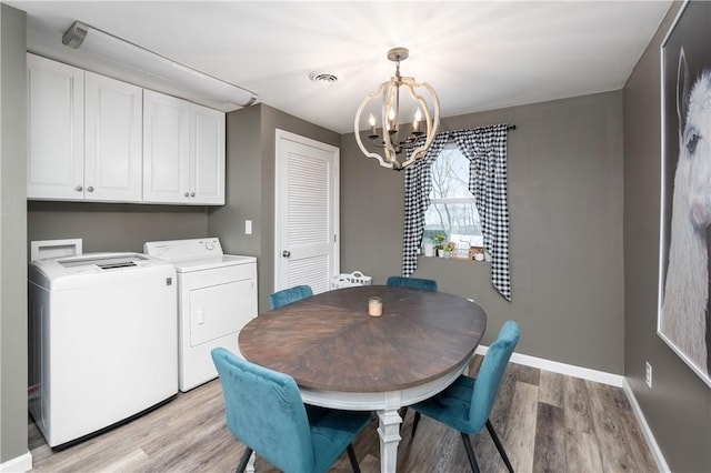 dining space with an inviting chandelier, light hardwood / wood-style floors, and washing machine and clothes dryer