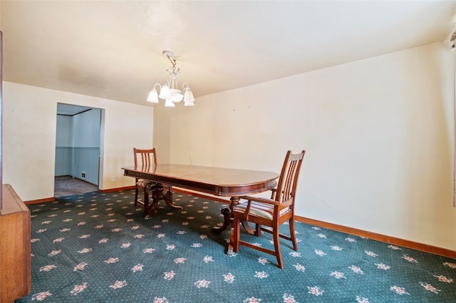 dining room with carpet flooring and an inviting chandelier