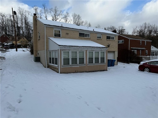 snow covered back of property featuring cooling unit