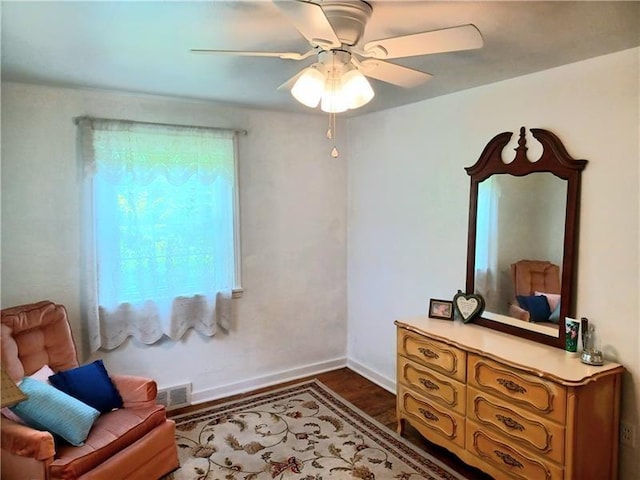 sitting room featuring dark wood-type flooring and ceiling fan