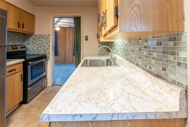 kitchen featuring ceiling fan, stainless steel electric stove, tasteful backsplash, and sink