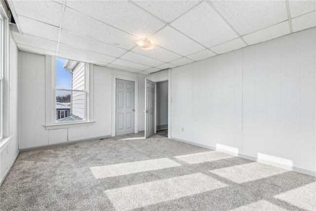 spare room with a drop ceiling and light carpet