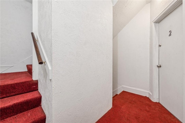 stairway with carpet floors and vaulted ceiling