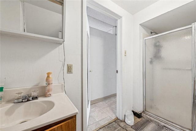 bathroom featuring a shower with door and vanity