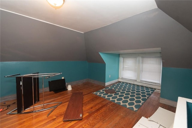 additional living space featuring vaulted ceiling and hardwood / wood-style flooring