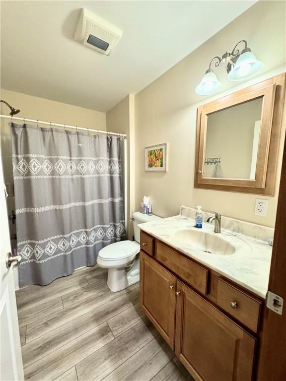 bathroom featuring toilet, a shower with curtain, and vanity